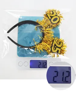 Detail showing the 21.2g weight of the 2025 gold glitter New Year party headband on a scale