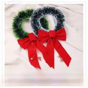Detail of Christmas wreath featuring red velvet bow, gold bells and pine needles