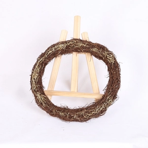 Handcrafted brown rattan Christmas wreath with gold glitter accents on a wooden easel