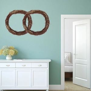 Detail of handcrafted round wicker wreaths made of natural dried vines on a soft blue wall