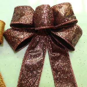 Close-up of a large bronze glitter bow featuring a metallic texture for holiday decoration