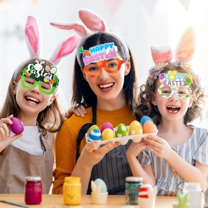Tre bambini che indossano occhiali colorati da coniglietto e uova di Pasqua per le feste