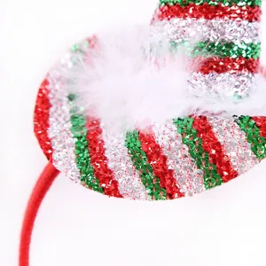 Close-up of festive mini top hat headband with red green sequins and white feathers