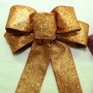 Detail of the high-density gold glitter coating and stitching on a large decorative bow