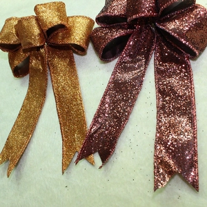 Close-up of orange and brown glitter bows with shimmering texture for festive decor