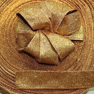 Close-up of orange-gold glitter ribbon material for Halloween party decor and gift wrapping