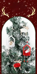 Detail of plush elk and wooden house ornaments hanging on a snowy Christmas tree