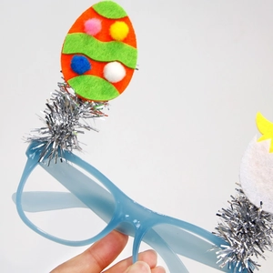 Detalle de gafas de Pascua con montura azul, huevos de fieltro y adorno plateado