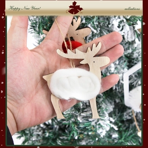 Handcrafted wooden reindeer ornament with white plush detail hanging on a green Xmas tree