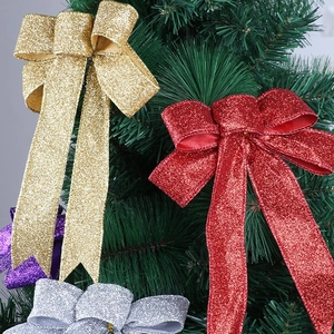 Close-up of sparkling Christmas tree bows with glitter finish on pine branches