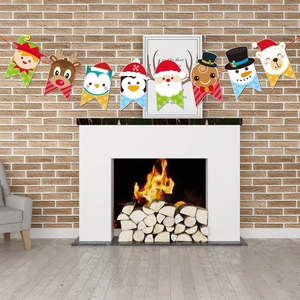 Detailed view of Christmas paper banner with Santa and reindeer motifs hanging on a fireplace