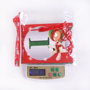 Weight measurement of packaged Christmas banner with festive cartoons on scale
