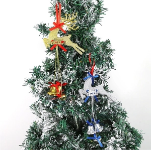 Close-up of gold and silver reindeer ornaments with Merry Christmas engraving on a tree