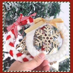Detail of handmade plush Christmas wreaths with snowflake and Happy Holiday text