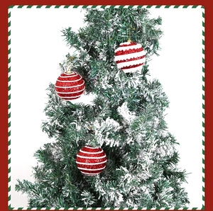 Close-up of red and white striped Christmas ornaments with glitter on tree branches