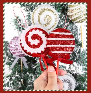 Détail de sucettes de Noël scintillantes avec nœuds en velours sur un sapin