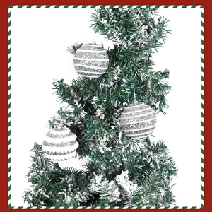 Close-up of white glitter stripe Christmas foam ball ornaments hanging on a snowy pine tree