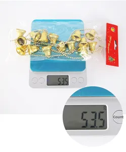 Weight measurement of 2m gold Christmas tree bell garland showing 53.5g on a digital scale