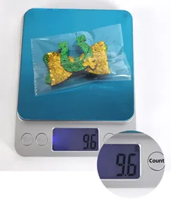 Pince à cheveux trèfle vert Saint-Patrick pesant 9,6g sur une balance numérique