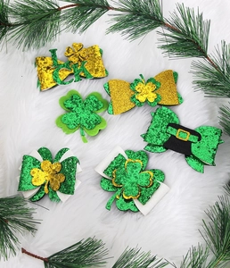 Dettaglio delle mollette glitterate per San Patrizio con trifogli fortunati e fiocchi