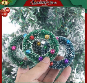Gros plan de mini couronnes de Noël avec aiguilles de pin, texture neige et grelots colorés