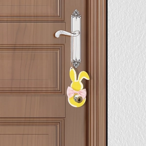 Easter yellow wooden bunny hanging ornament with pink bow on a wooden door handle