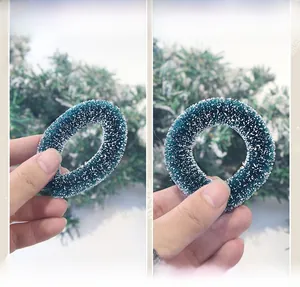 Vue détaillée d'une mini couronne de Noël avec effet neige et structure pliable