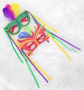 Detailed view of colorful carnival masks with feathers and ribbons on white faux fur