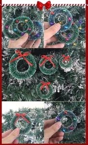 Mini couronnes de Noël avec nœuds rouges et cloches sur aiguilles de pin enneigées