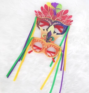 Detail of Mardi Gras party eye masks with feathers and colorful tassels on white fur