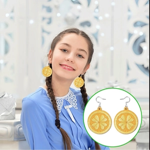 Detail view of yellow lemon slice drop earrings with glitter texture and silver fish hooks
