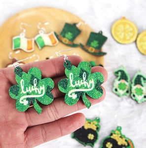 Close-up of glittery green clover earrings with lucky lettering for Saint Patrick's Day
