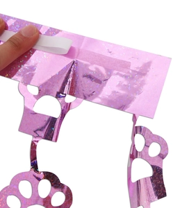 Detail of pink laser party fringe curtain with adhesive tape and cat paw shape cutouts