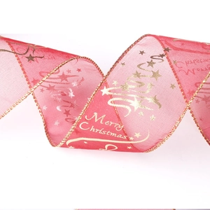 Close-up of red Christmas ribbon with golden Merry Christmas text and star patterns