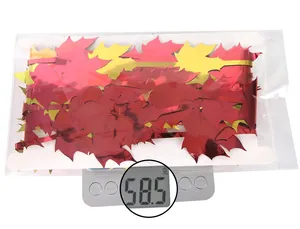 Detailed view of red and gold foil maple leaf fringe curtain weighing 58.5g on a scale