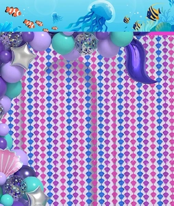 Detail of seashell tinsel curtains and purple balloon arch for mermaid themed party decor