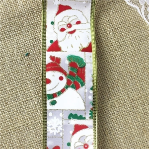 Detail of Christmas snowman ribbon with gold wired edges on burlap background