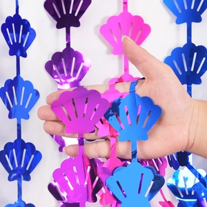 Close-up of shiny shell-shaped foil garlands in purple, pink and blue for party decor