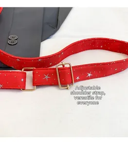 Détail de la bandoulière rouge réglable avec étoiles argentées et boucles dorées