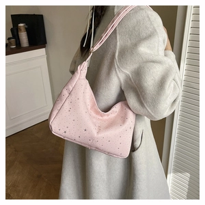 Vue latérale d'un sac hobo rose avec motifs d'étoiles argentées et bandoulière réglable