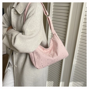 Sac fourre-tout rose en velours avec motifs d'étoiles argentées porté à l'épaule d'un mannequin