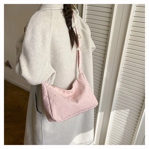 Sac bandoulière rose à étoiles argentées sur mannequin, avec sangle réglable