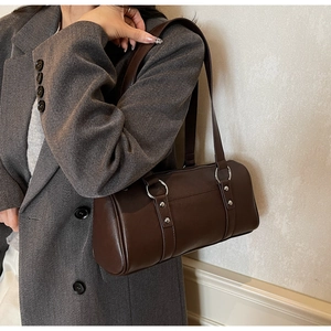 Vue détaillée du sac Boston marron foncé avec anneaux argentés et rivets décoratifs