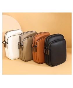 Detail view of four mini crossbody bags in white, beige, brown, and black lychee grain leather