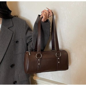 Vue détaillée du sac polochon en cuir ciré marron foncé avec anneau argenté et rivets