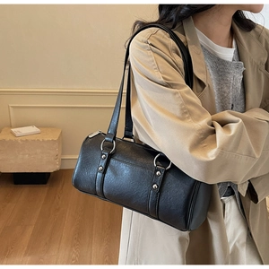 Détail du sac polochon en cuir ciré vintage avec anneaux argentés et rivets