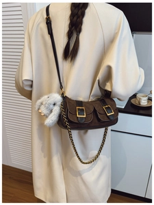 Detailed side view of a brown vintage baguette bag featuring dual pockets and golden buckles