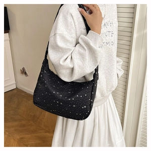 Détail du sac cabas en nylon noir avec imprimés d'étoiles et fermeture éclair en métal