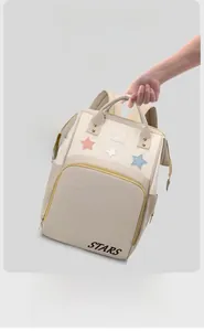 Detail view of lightweight beige insulated backpack featuring star patterns and star text