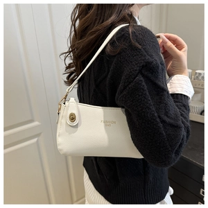 Close-up of white lychee pattern leather shoulder bag with gold twist lock and logo